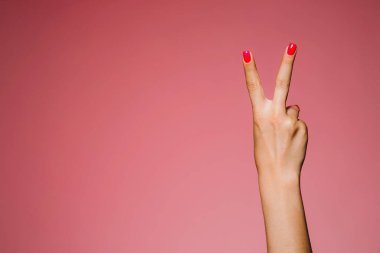 Pembe arka plan barış jestine izole edilmiş parlak manikürlü kadınların elleri.