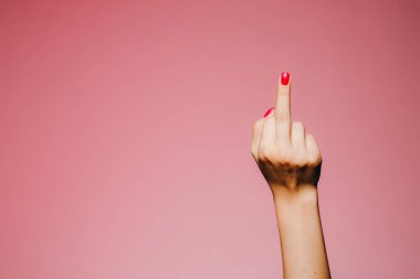 Pembe arka planda izole edilmiş, parlak manikürlü bir kadının elleri.