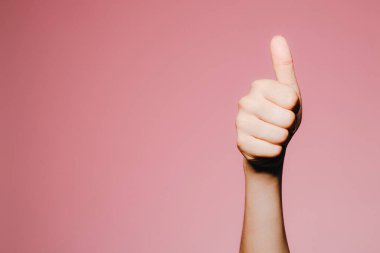 Pembe arka planda izole edilmiş, parlak manikürlü bir kadının eli havada.