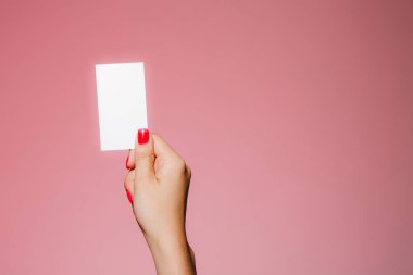 Kadının eli boş. Pembe üzerine izole edilmiş bir kartvizit.