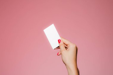 Kadının eli boş. Pembe üzerine izole edilmiş bir kartvizit.