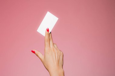 Kadının eli boş. Pembe üzerine izole edilmiş bir kartvizit.