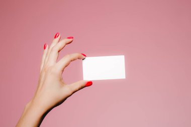 Kadının eli boş. Pembe üzerine izole edilmiş bir kartvizit.