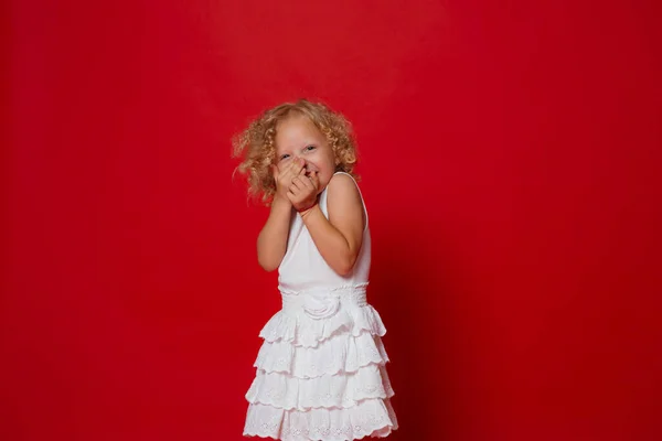 Linda Menina Encaracolado Loira Vestido Branco Rindo Isolado Vermelho — Fotografia de Stock