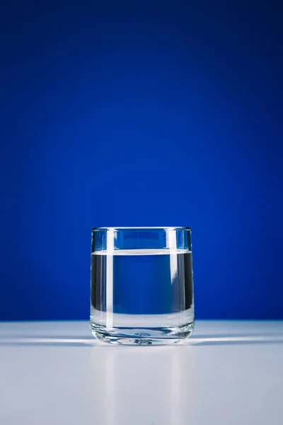 Vidro Água Parada Isolado Fundo Azul — Fotografia de Stock