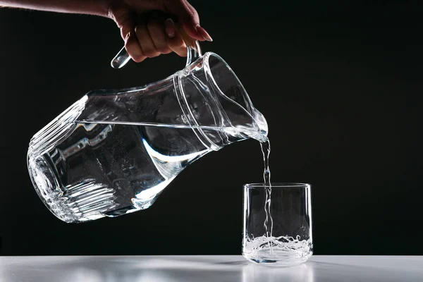 Hand Pouring Water Glass Jug Glass Isolated Black Background — Stock Photo, Image