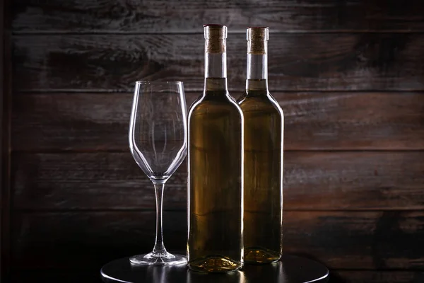 Δύο Λευκά Μπουκάλια Κρασιού Ένα Άδειο Ποτήρι Ένα Τραπέζι Ξύλινο — Φωτογραφία Αρχείου