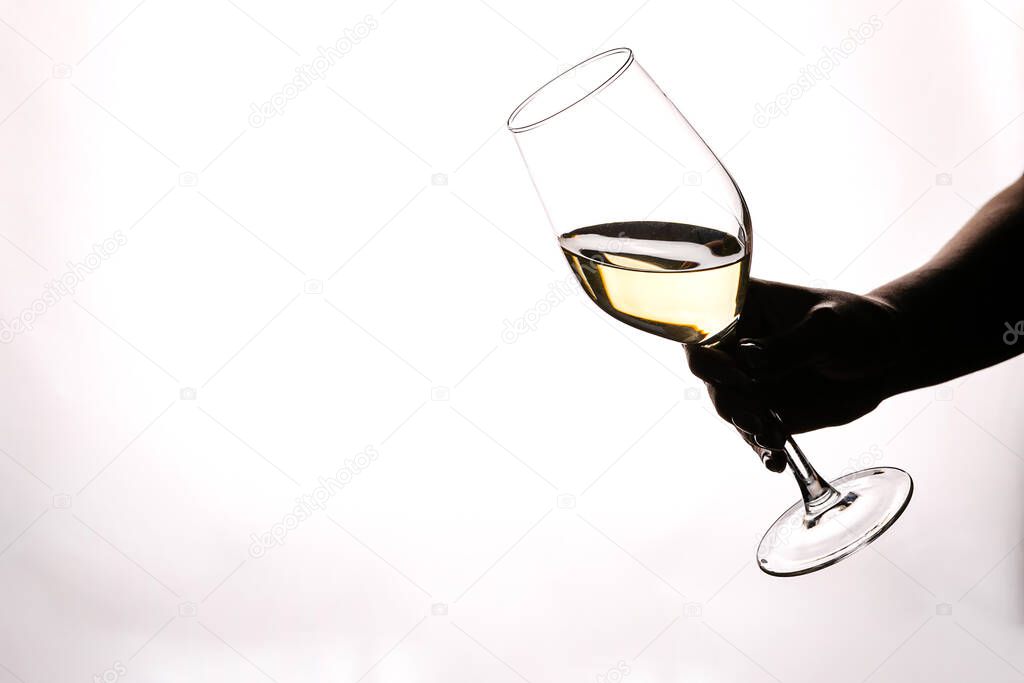 Female hand holding glass with white wine toasting isolated on a white background