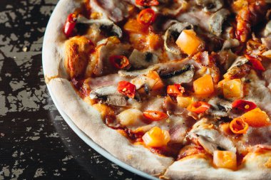 Eritilmiş peynirli, domatesli, biberli, mantarlı ve şifalı otlu İtalyan pizzasını yakın. Lezzetli sıcak pizza..