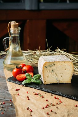 Baharatlı ev yapımı beyaz peynir ve kiraz ve fesleğen. Koyu ahşap kesim tahtasında..