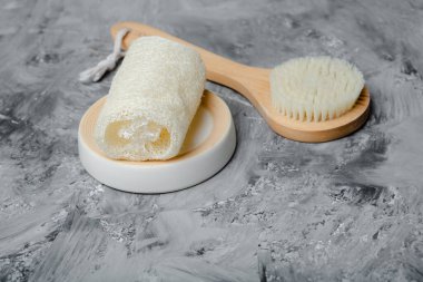 Çevre dostu kuru vücut fırçası ve sünger. Gri beton arka plan üzerinde geleneksel vücut bakımı kavramı.