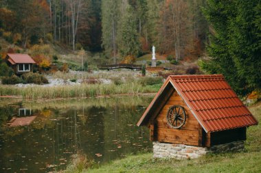 Dağlarda eski ahşap kuyu, sonbahar havası. Kırsal kesimde dinlenmek için mükemmel bir yer..