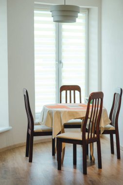 Evde yemek yiyorum. Yemek masası ve dört sandalye yakın çekim. Sıcak aile yemeği kavramı.