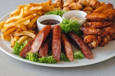 Sosis, patates kızartması, tavuk ve sosisli büyük boy sıcak bira tabağı..