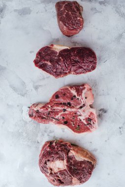 Biftek, biftek, pirzola, fileto, mermer bir masada sığır filetosu için farklı türde çiğ et..