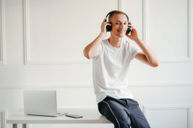 Telsiz kulaklıklı, müzik dinleyen genç bir adamın portresi.