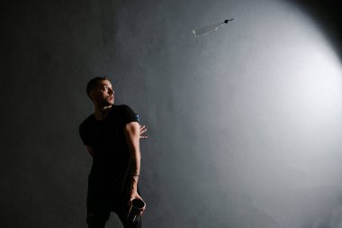 Profesyonel barmen, gri arka plandaki Mobile Bar 'da kokteyl için bir şişe ve karıştırıcıyla hokkabazlık yapıyor.