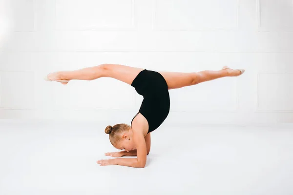 Elastyczna Gimnastyczka Ćwicząca Akrobatycznej Pozycji Podłodze Białym Tle — Zdjęcie stockowe