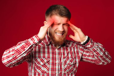 Yorgun ve sakallı bir adamın gömleğinin başı ağrıyor. Kızıl saçlı adam el ele tutuşuyor, acı çekiyor..