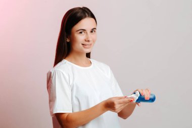 Genç bir kadının banyoda yüzünü yıkaması için pamuk diske losyon sürmesine yakın çekim. Güzellik, cilt bakımı.