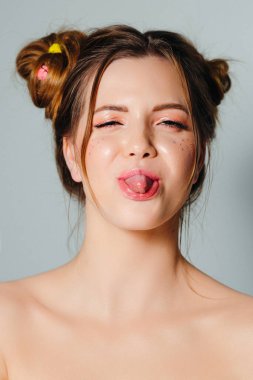 Genç ve güzel bir kadın sakız üflüyor. Saç stili olan bir kızın oyuncu portresi. Neşeli yaz kızı.