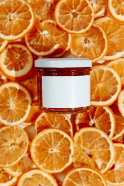 Kurumuş portakallardan oluşan bir arka planda yüz ve vücut için nemlendirici krem. Yaş karşıtı etki için el yapımı C vitamini ürünü.