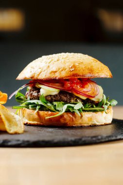 Domatesli sığır burger ve patates cipsi. Abur cubur. Fast food. Vücut pozitifi. Karantinadaki yiyecekler teslimattan. Menü için fotoğraf.