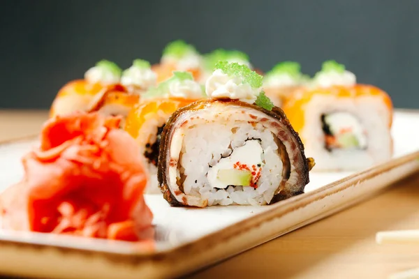 Sushi roll sett. Rice, nori, cream cheese, cucumber, fresh salmon, salmon roe, eel, sesame, unagi. Delivery food. Menu photo.