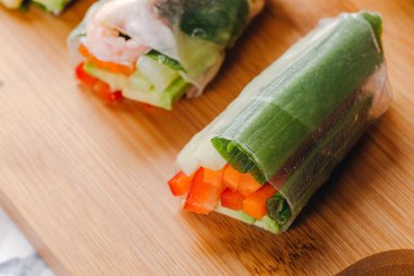 Taze börekleri karides, sebze ve farklı soslarla kapatın. Tahta bir tabakta servis edilir..