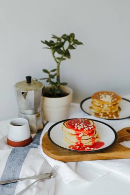 Mutfaktaki beyaz masada kahve makinesinin yanında krep. Karantinada sabah kahvaltısı. Ev yapımı lezzetli krep tarifi..