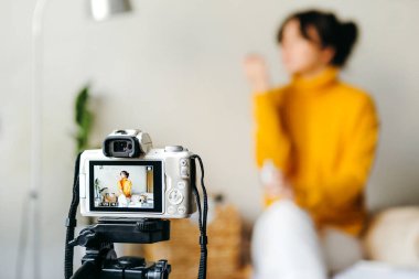 Genç esmer kız güzellik blogcusu kamerada cilt bakımı için nasıl sis yapılacağını gösteriyor. Blog çekmenin konsepti. Güzellik ve cilt bakımı.