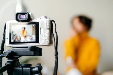 Genç esmer kız güzellik blogcusu kamerada cilt bakımı için nasıl sis yapılacağını gösteriyor. Blog çekmenin konsepti. Güzellik ve cilt bakımı.