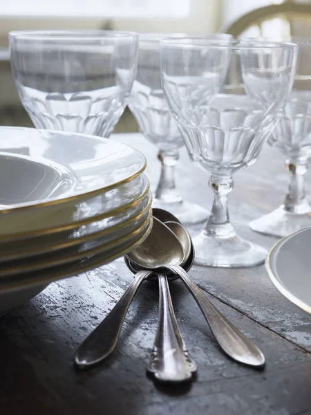 Platos, cucharas y vasos de beber en la mesa - foto de stock