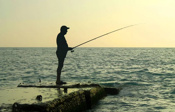 釣り竿でビーチの漁師は魚をキャッチ — ストック写真