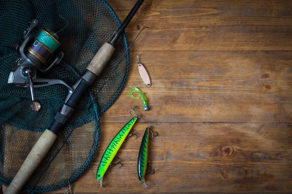 钓鱼纺纱 鱼钩和鱼饵上的变暗木背景 顶视图 — 图库照片