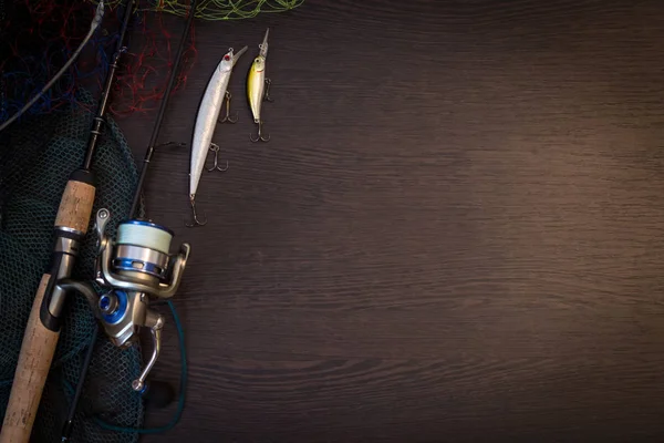钓鱼纺纱 鱼钩和鱼饵上的变暗木背景 顶视图 — 图库照片