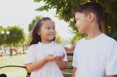 Sevimli küçük çocuklar parkta güneşli bir günün tadını çıkarıyorlar.