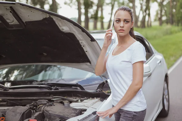 Joven hermosa mujer con un coche roto en la carretera — Foto de Stock