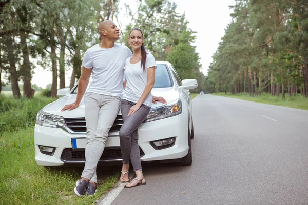 Vackra multiracial par njuter resa med bil — Stockfoto