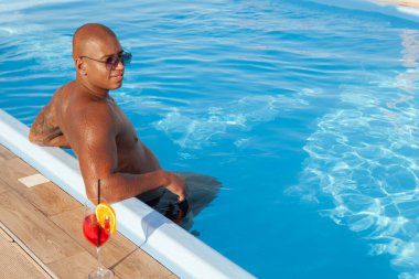 Yakışıklı atletik Afrikalı adam sahilde güneşleniyor.