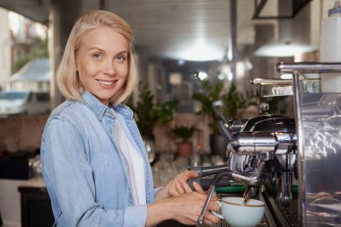 Yerel kahve dükkanında çalışan çekici bayan barista.