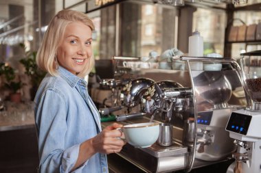 Yerel kahve dükkanında çalışan çekici bayan barista.