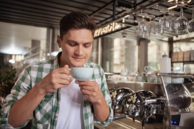 Kahve dükkanında çalışan yakışıklı bir barista.