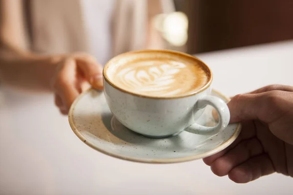 Barista müşteriye bir fincan kahve veriyor.