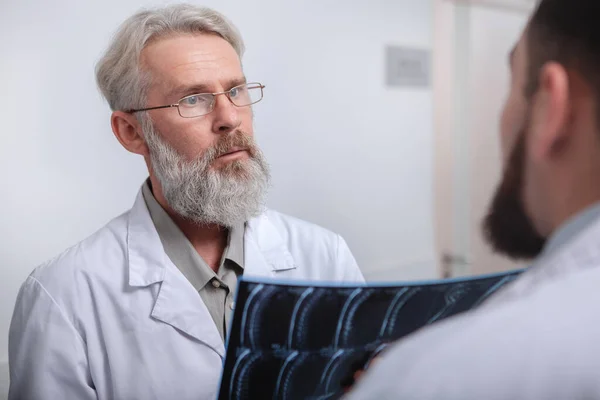 Médico senior hablando con un colega en el hospital — Foto de Stock