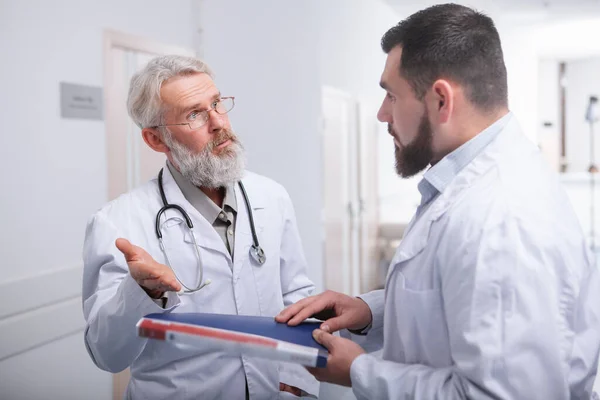 Senior male doctor talking to a colleague at the hospital