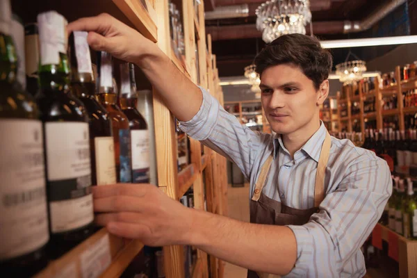 Jovem sommelier masculino trabalhando na loja de vinhos — Fotografia de Stock