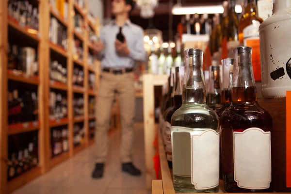 Bonito jovem compras na loja de vinhos — Fotografia de Stock