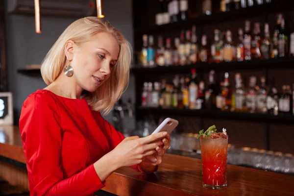 Young Beautiful Woman Red Dress Using Her Smart Phone Bar — Stock Photo, Image