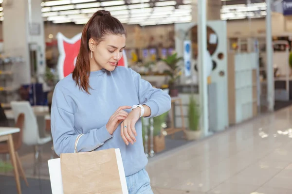 Jovem Mulher Bonita Usando Seu Relógio Inteligente Enquanto Faz Compras — Fotografia de Stock